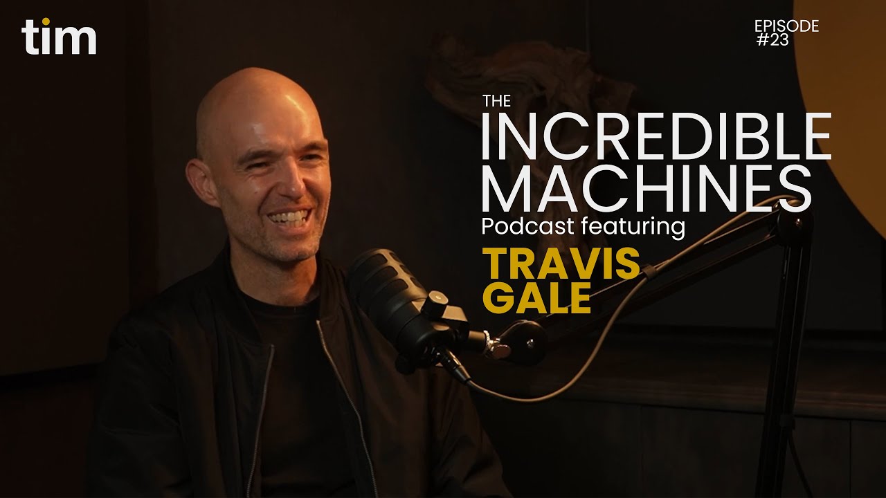 Travis Gale appearing on The Incredible Machines Podcast Episode 23, captured mid-smile as he speaks into a microphone in Tim Africa's signature studio design.