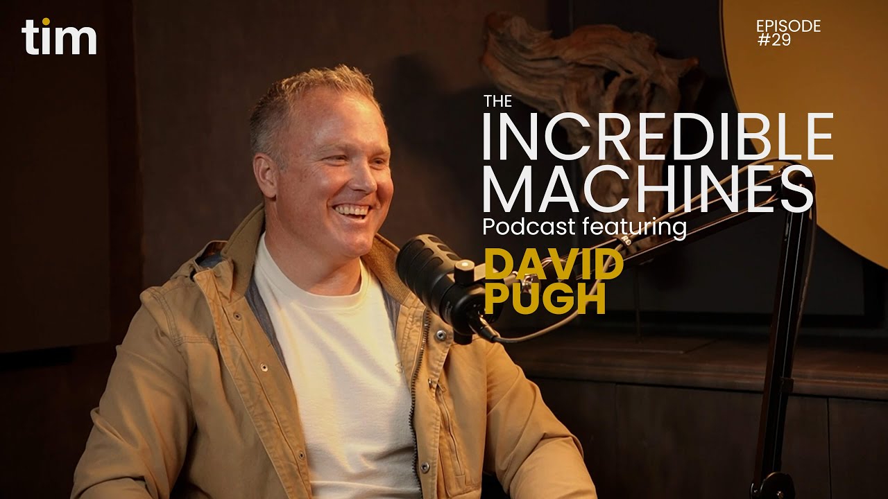 David Pugh on The Incredible Machines Podcast at TIM Africa, seated in a black and mustard-yellow studio with warm lighting, mid-discussion. The background features minimalist acoustic panels and professional audio equipment, showcasing a modern South African podcast setup focused on innovation, leadership, and storytelling.